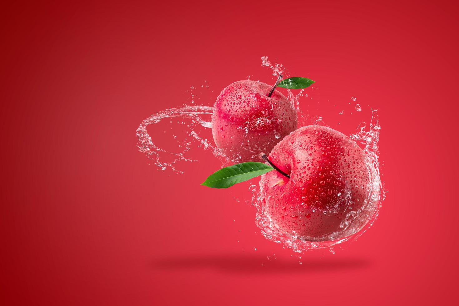 água espirrando na maçã vermelha fresca foto