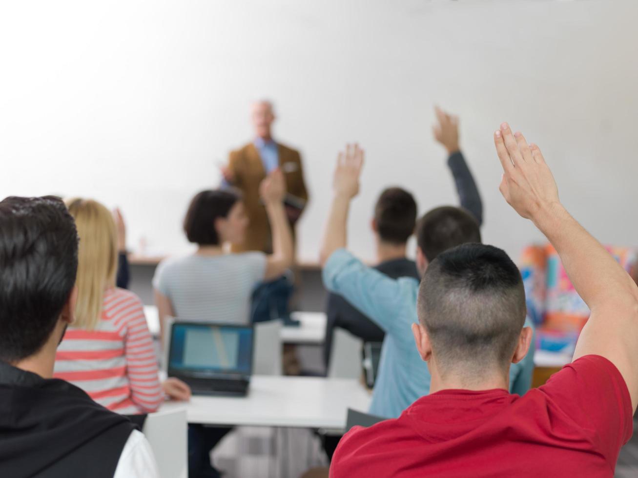 grupo de alunos levanta as mãos na aula foto