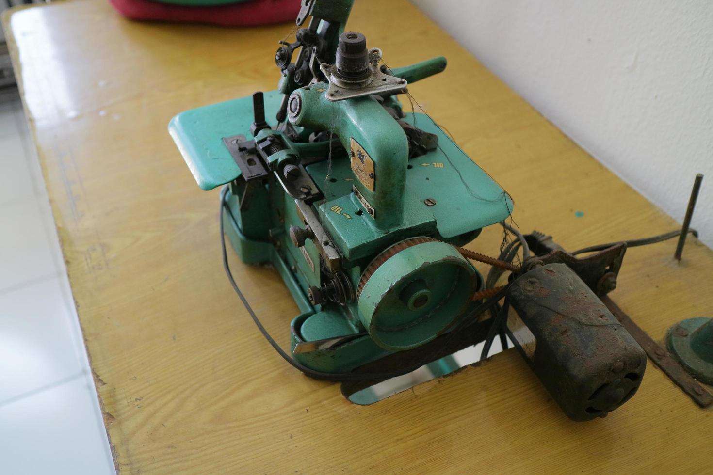 uma máquina overlock verde para costurar roupas é colocada sobre a mesa foto