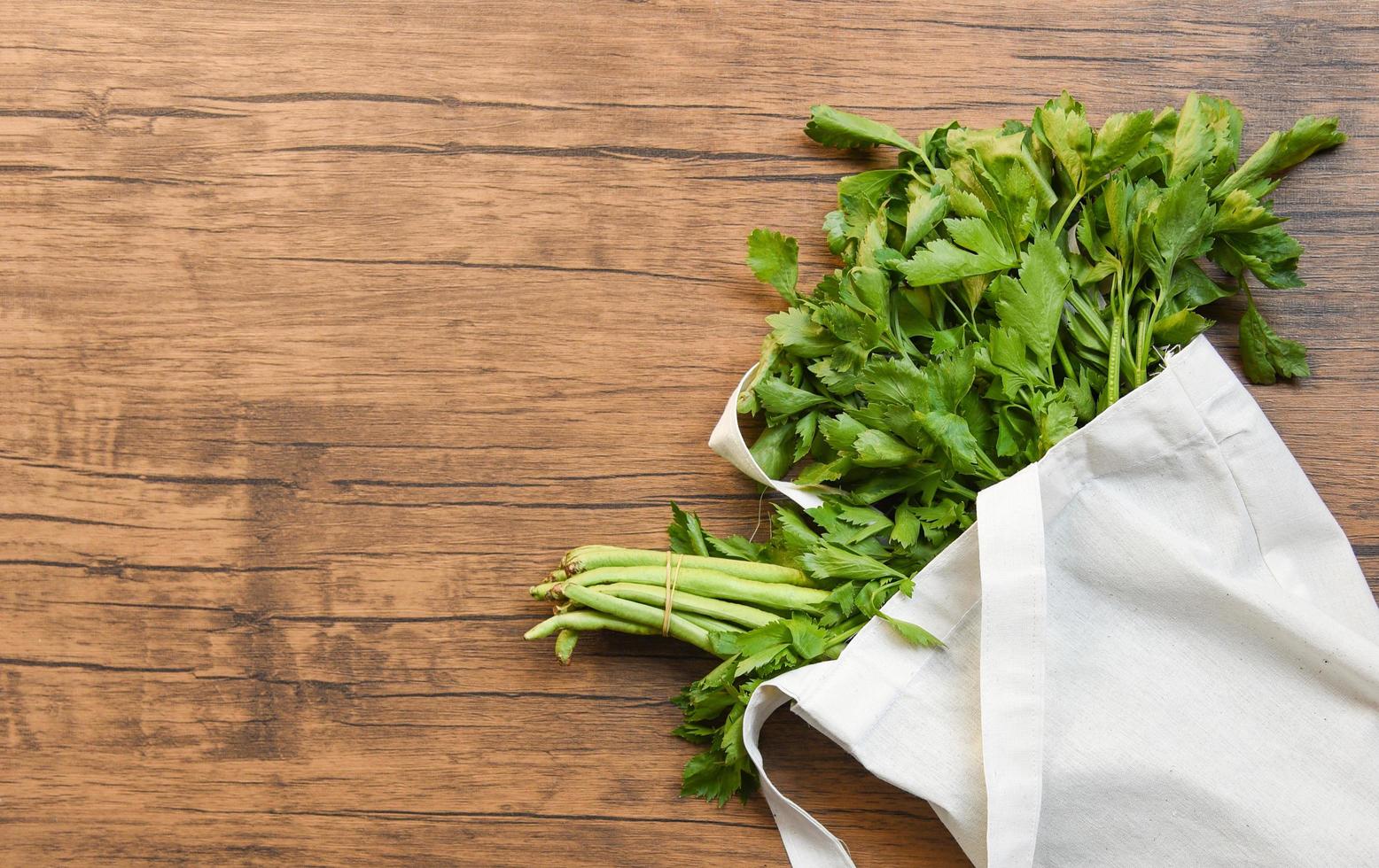 zero desperdício use menos conceito de plástico legumes frescos orgânicos em sacos de tecido de algodão ecológico na mesa de madeira foto