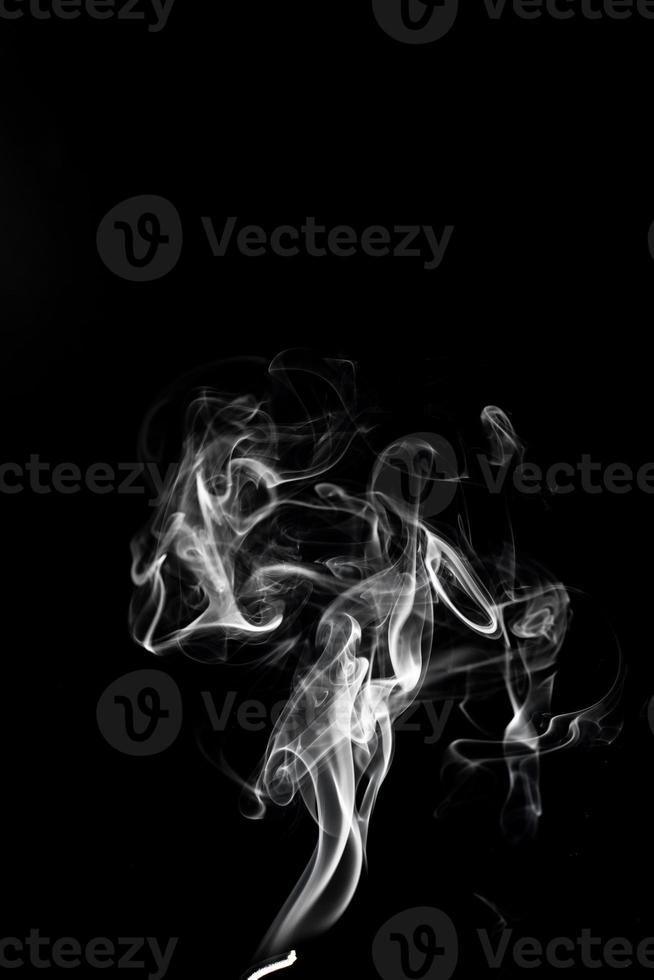 uma única fumaça branca queima de incenso, filmada em estúdio com fundo preto escuro, para o conceito de design e religião foto