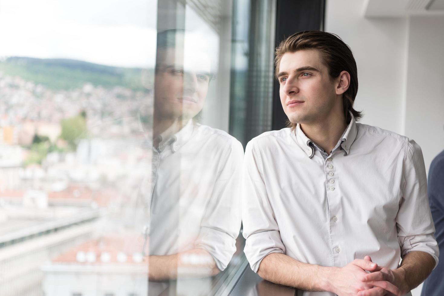 jovem empresário no escritório de inicialização pela janela foto