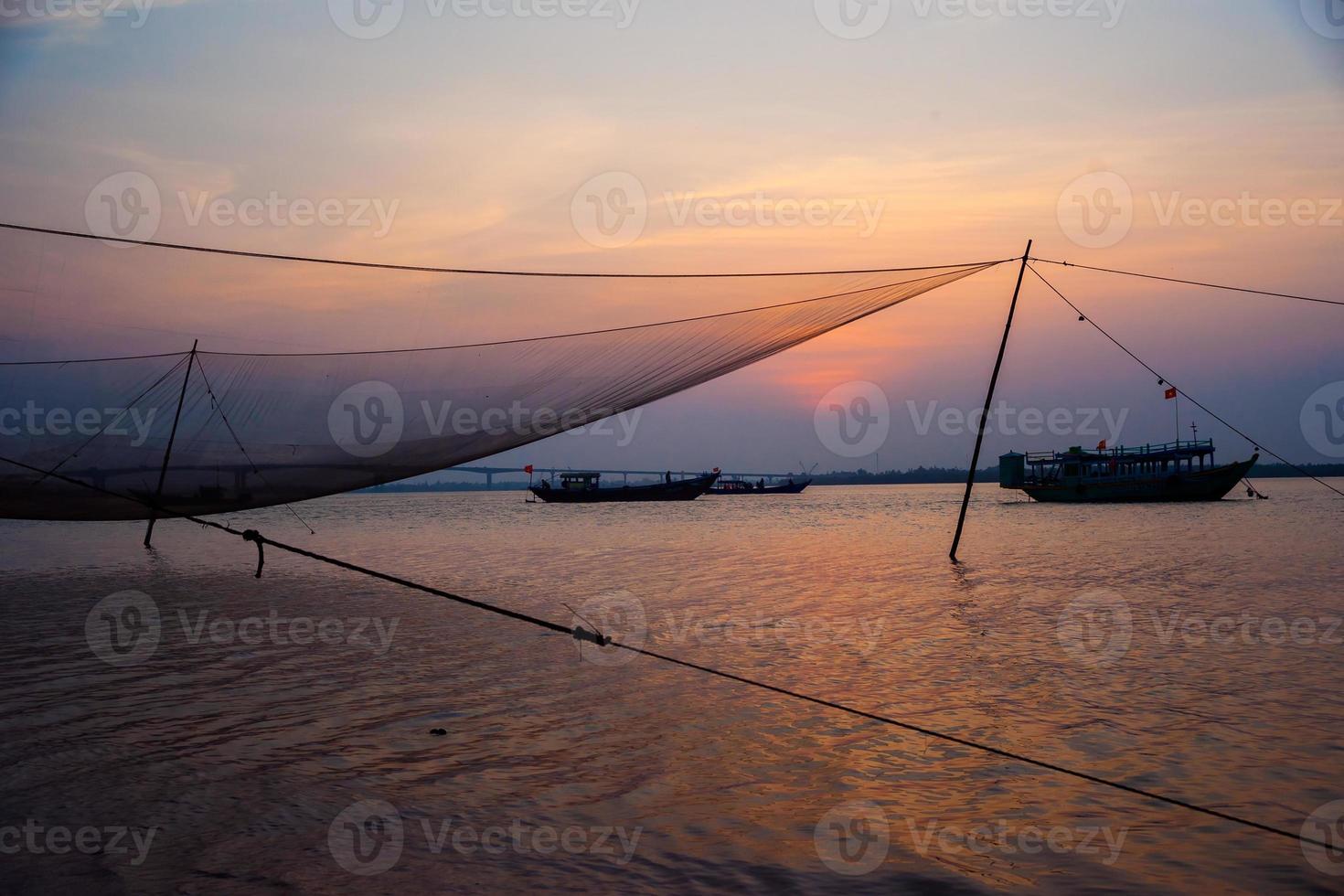 cena calma de rede de pesca contra o pôr do sol roxo. foto