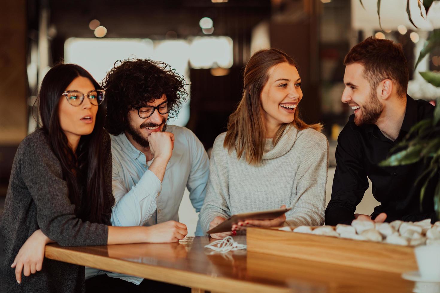 um grupo de amigos saindo em um café e conversando sobre negócios foto