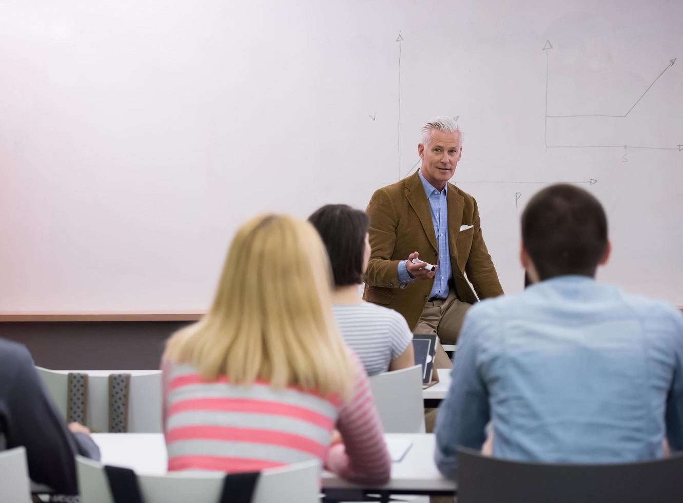 professor com um grupo de alunos em sala de aula foto