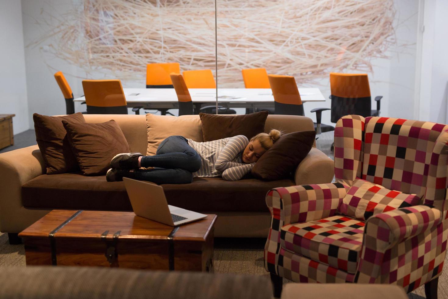 mulher dormindo em um sofá em um escritório criativo foto