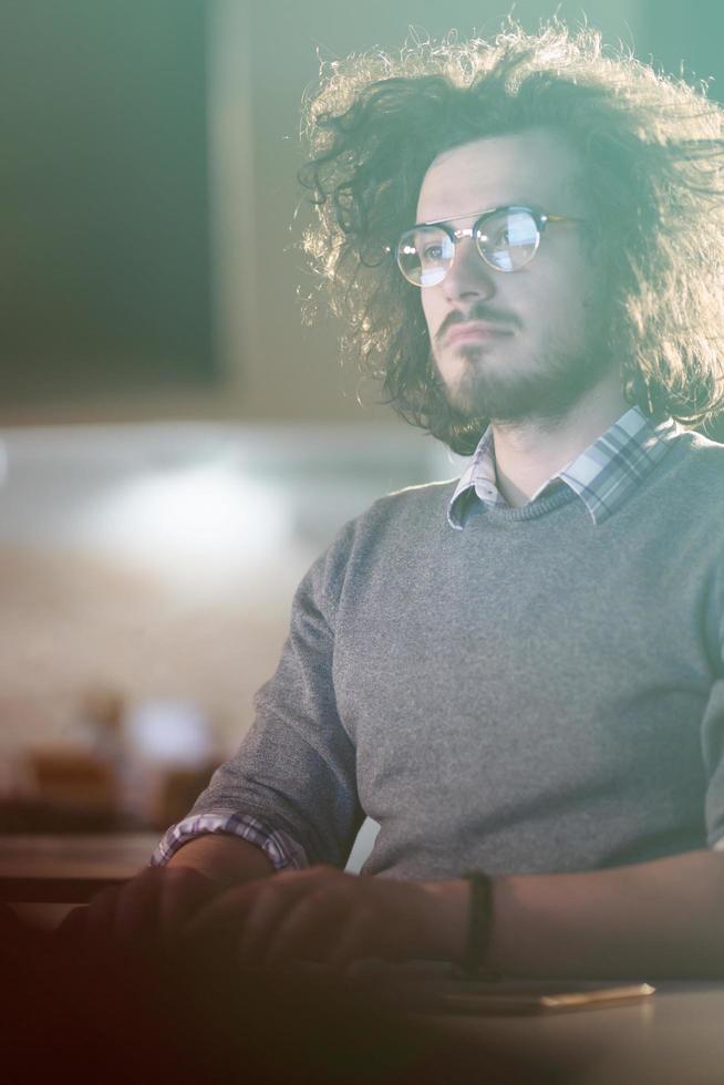 homem trabalhando no computador no escritório escuro foto