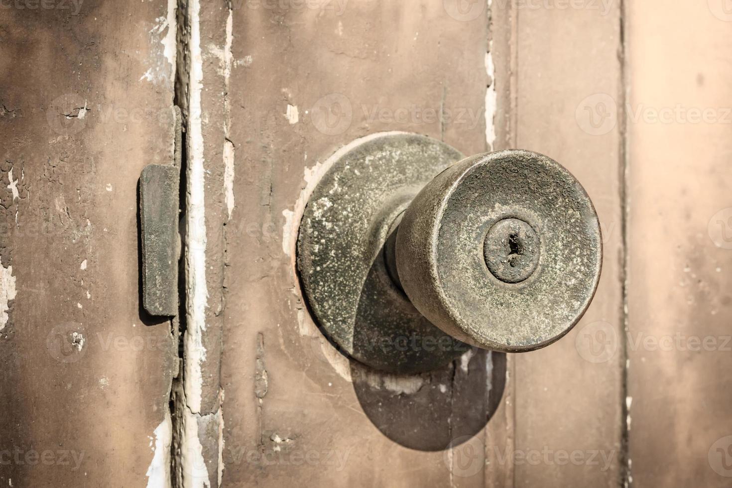 maçaneta da porta rústica na velha porta de madeira. foto