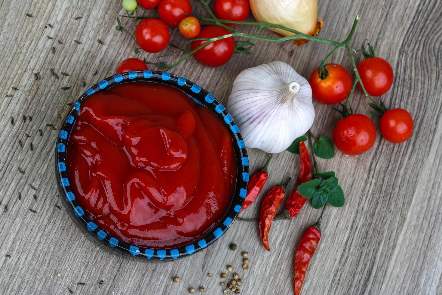 ketchup de tomate em uma tigela no fundo de madeira foto