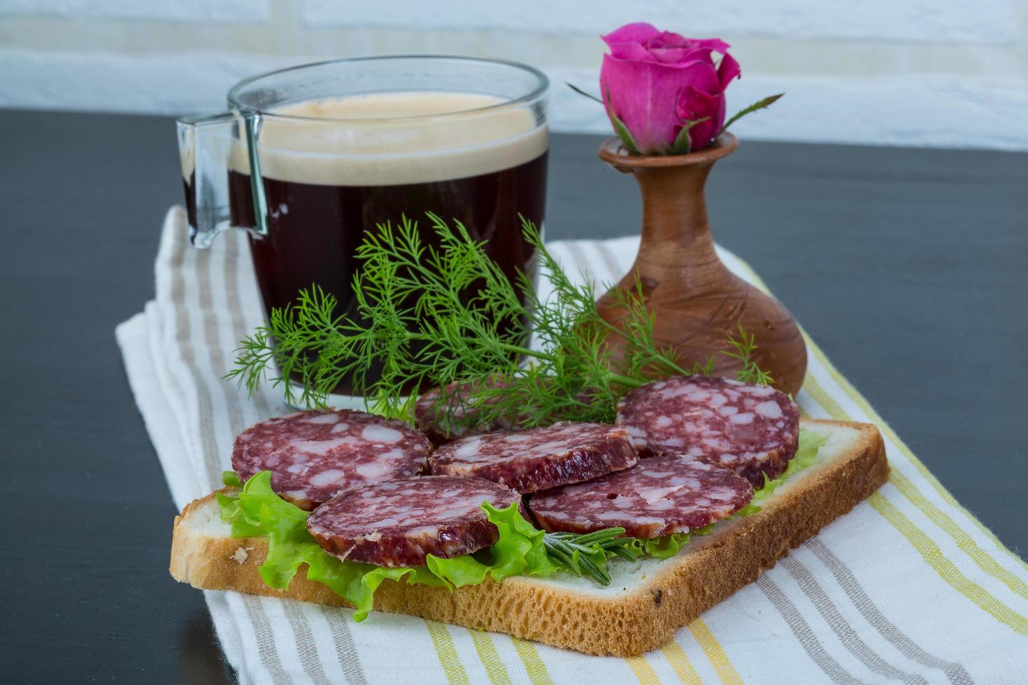 sanduíche de salame em fundo de madeira foto