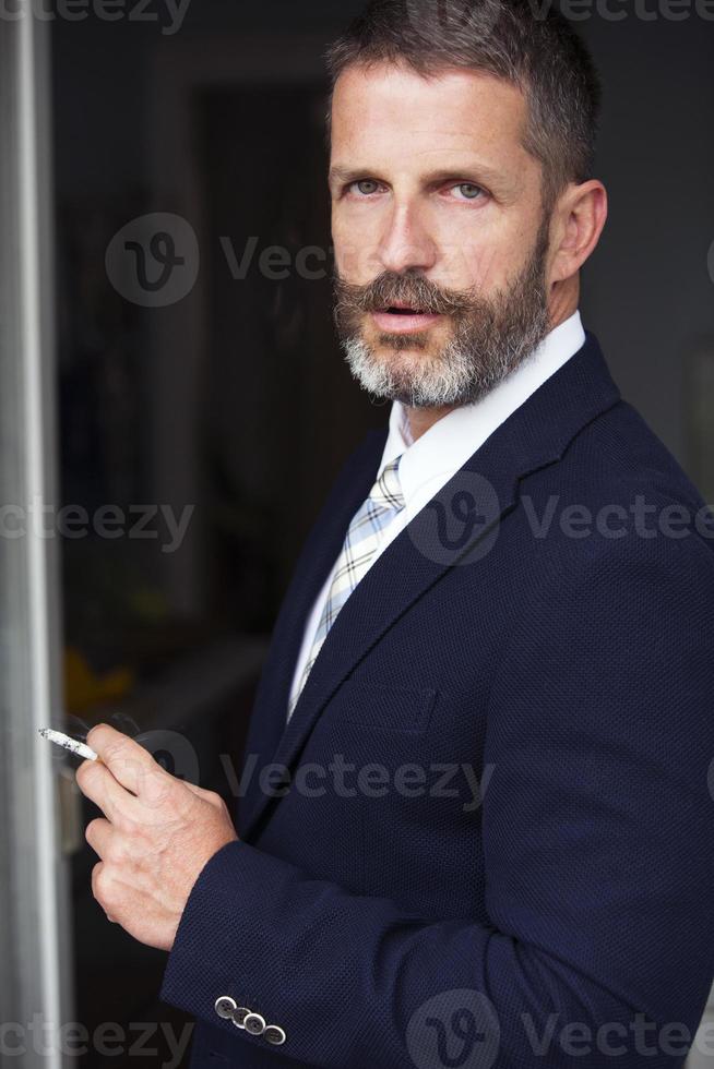 retrato de empresário fumando um cigarro foto