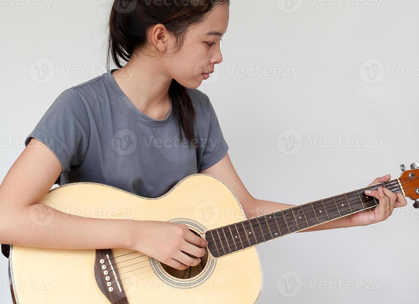 menina bonita praticando violão. foto