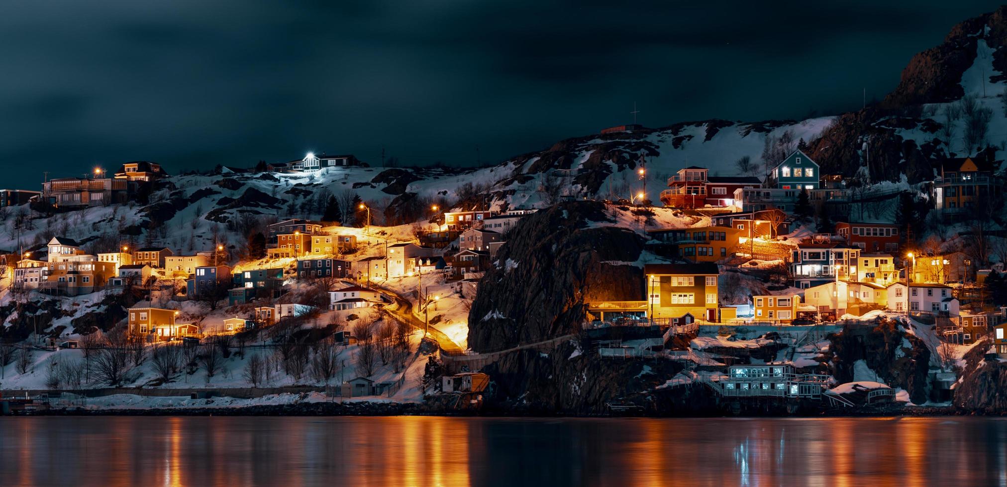 edifícios iluminados da cidade perto de corpo d'água foto