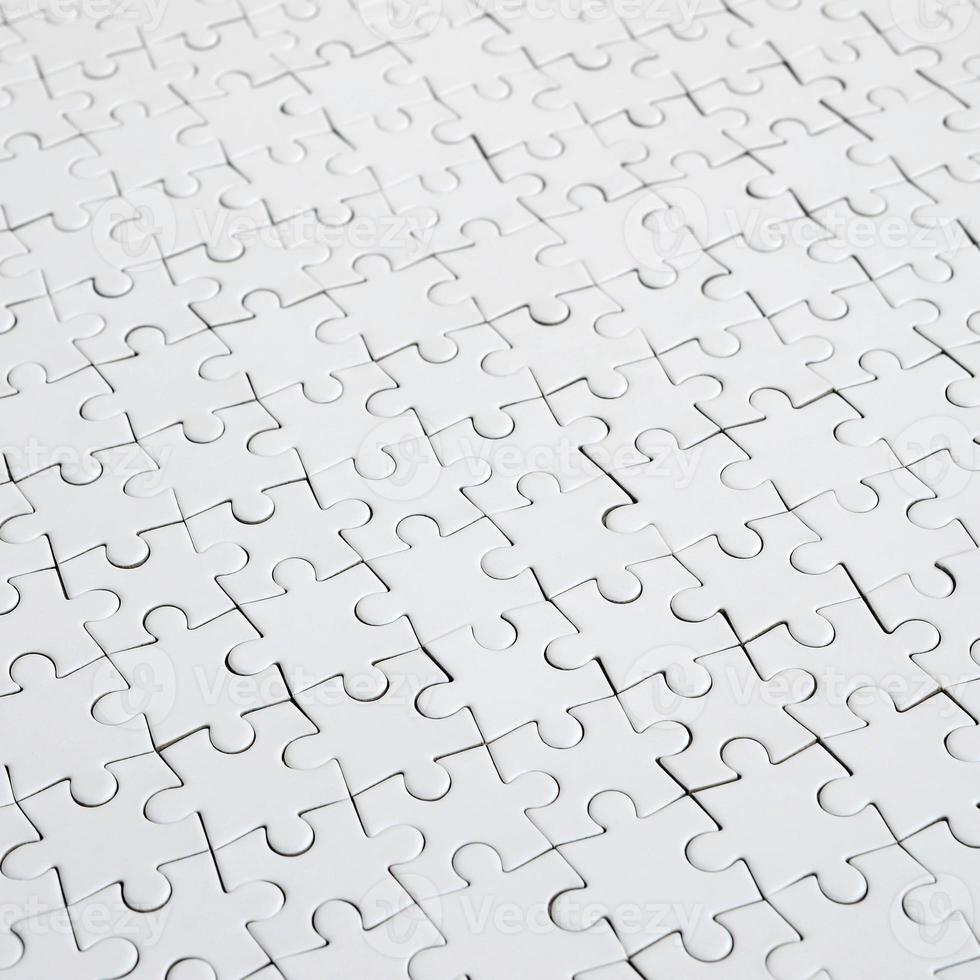 close-up de um quebra-cabeça branco em estado montado em perspectiva. muitos componentes de um grande mosaico inteiro estão unidos foto