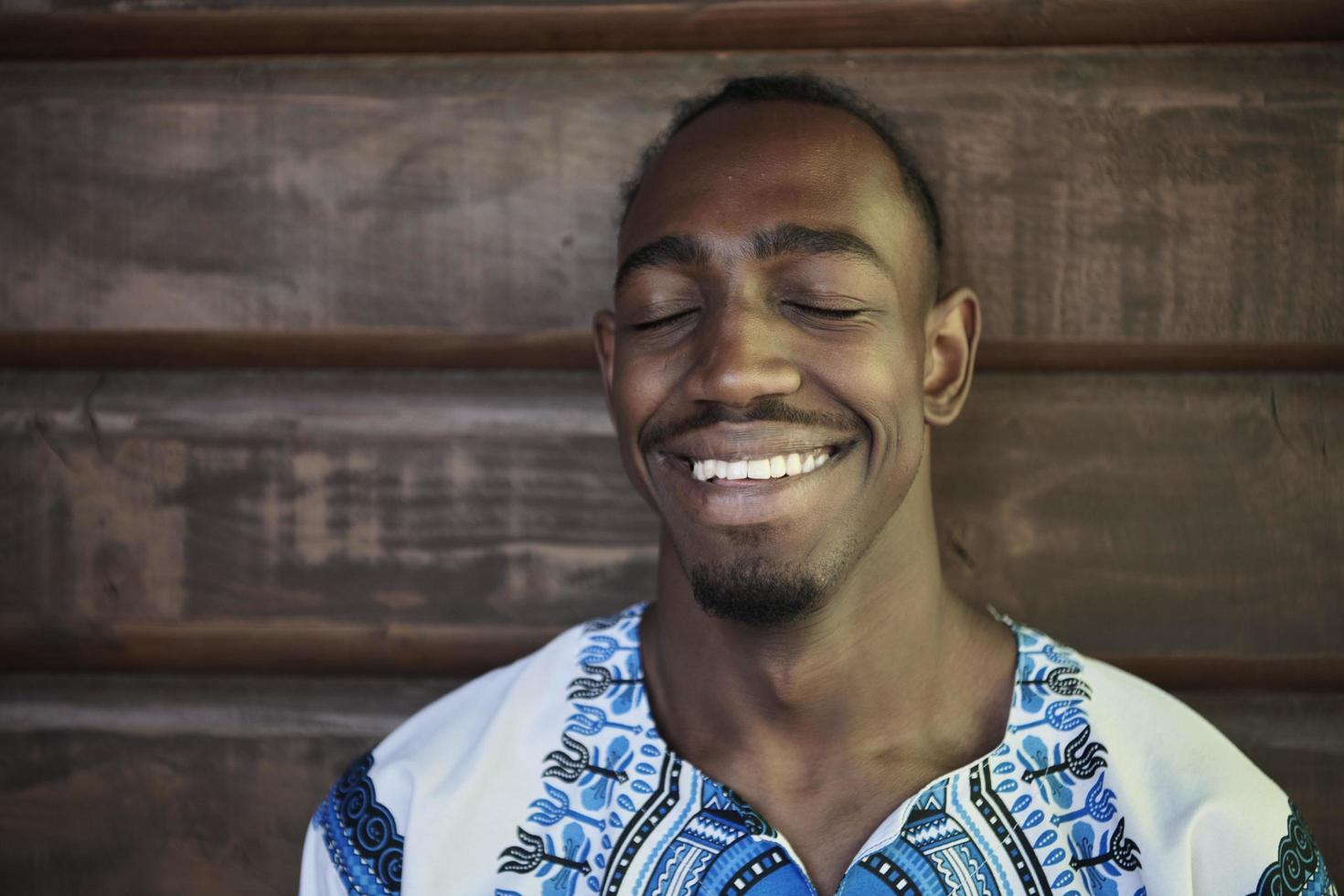 retrato de um jovem africano sorridente vestindo roupas tradicionais foto