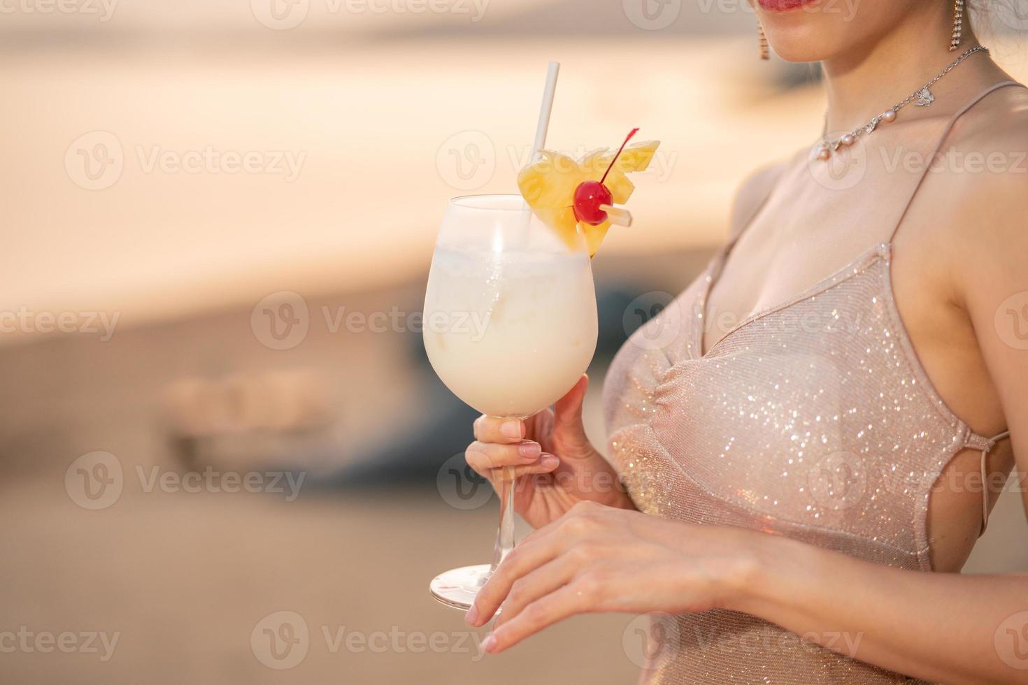 mulher bebendo coquetéis na praia, momento romântico do pôr do sol. férias de verão. foto