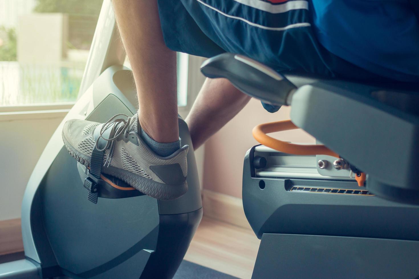 jovem usando uma bicicleta ergométrica em um centro de fitness indoor foto