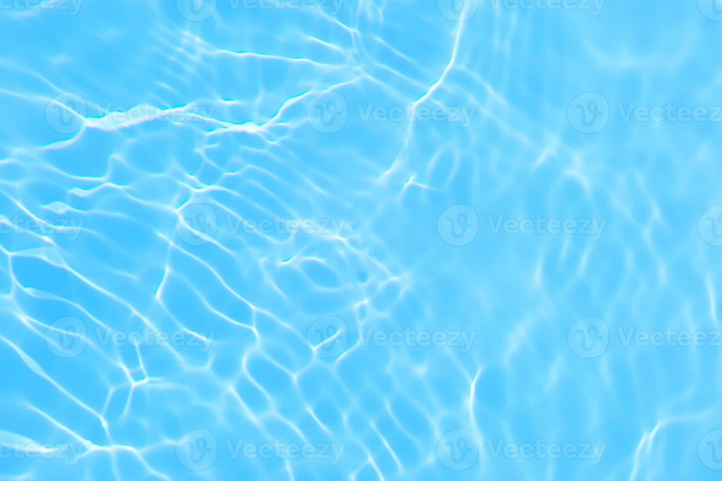 desfocar a textura de superfície de água calma de cor azul transparente turva com respingo, bolha. fundo de ondulação de água azul brilhante. superfície da água na piscina. água de bolha azul brilhando. foto