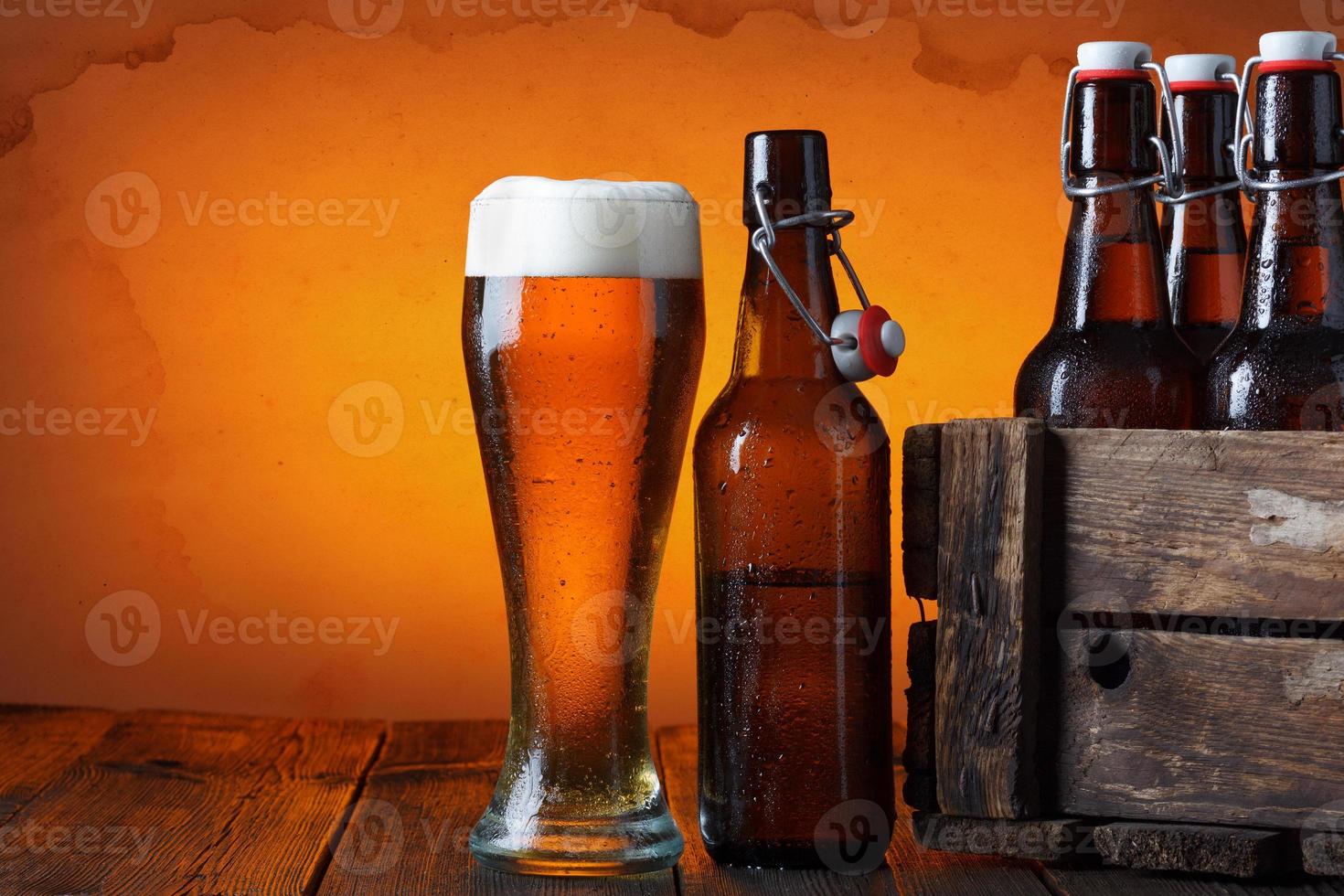 copo de cerveja com caixote de madeira com garrafas foto