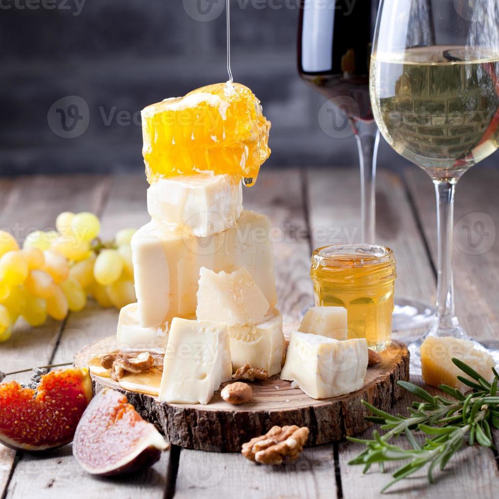 uva, queijo, figos e mel com um copo de vinho. foto