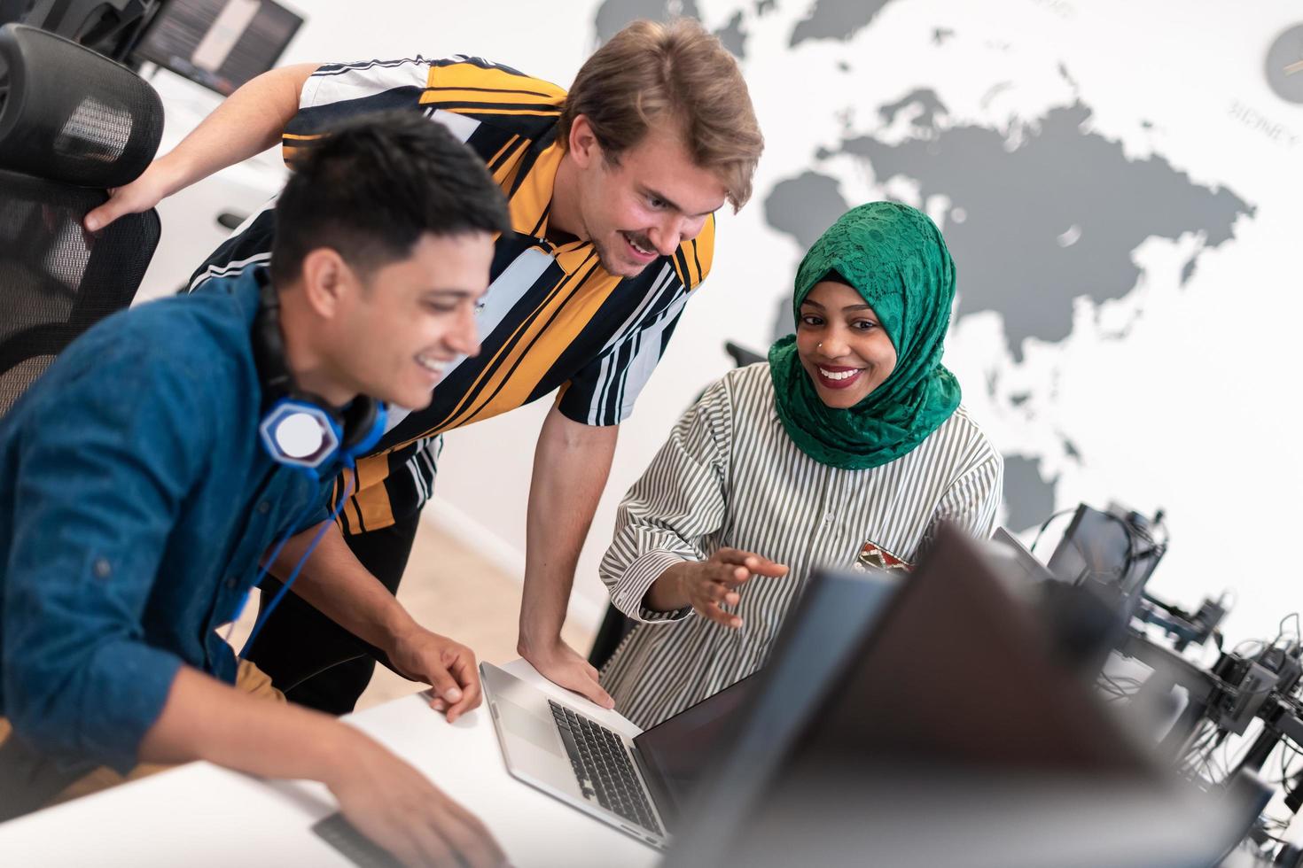 multiétnica equipe de negócios de inicialização mulher árabe vestindo um hijab na reunião no moderno escritório de plano aberto brainstorming interior, trabalhando no laptop e computador desktop. foco seletivo foto