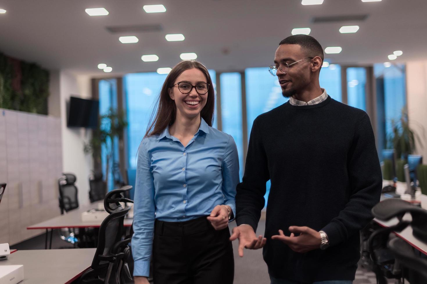 duas pessoas felizes da equipe de negócios executivos profissionais diversos mulher e homem afro-americano andando no escritório de coworking. retrato de equipe de gerentes de empresa multicultural. foto