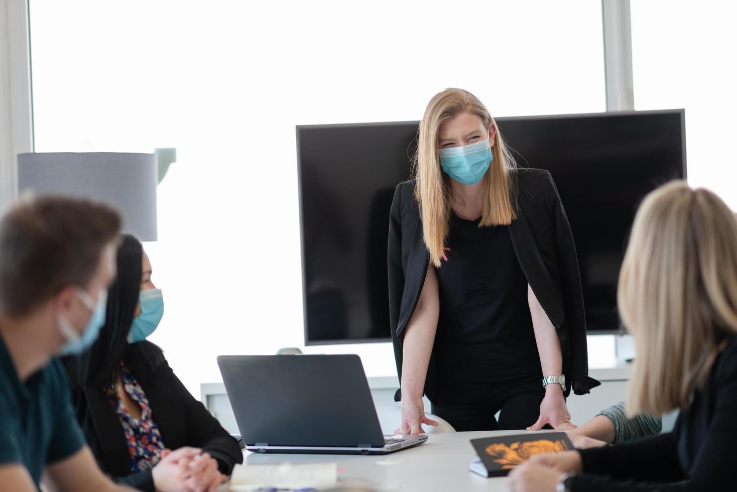 pessoas de negócios reais em reunião usando máscara protetora foto