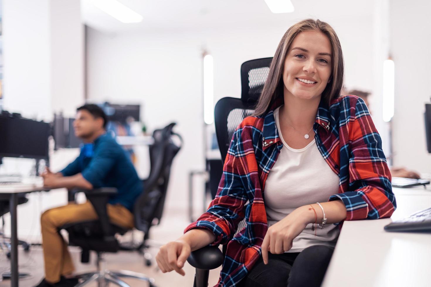 mulher de negócios casual trabalhando no computador desktop no interior do escritório de inicialização de plano aberto moderno. foco seletivo foto