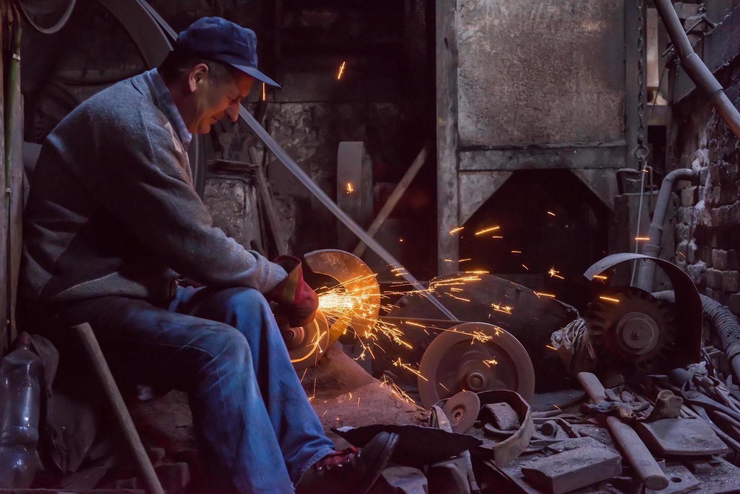 o ferreiro polindo produtos de metal foto