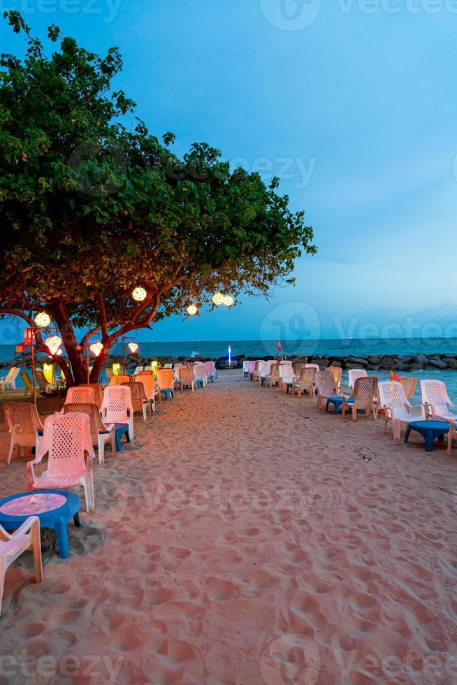 cadeira de praia com mesa de jantar perto da praia do mar foto