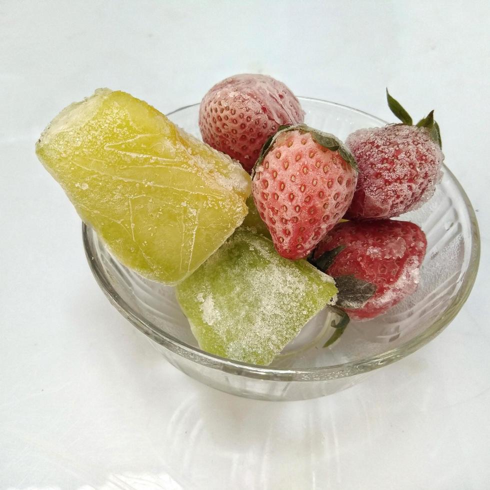 morango congelado e melão congelado isolado no fundo branco foto