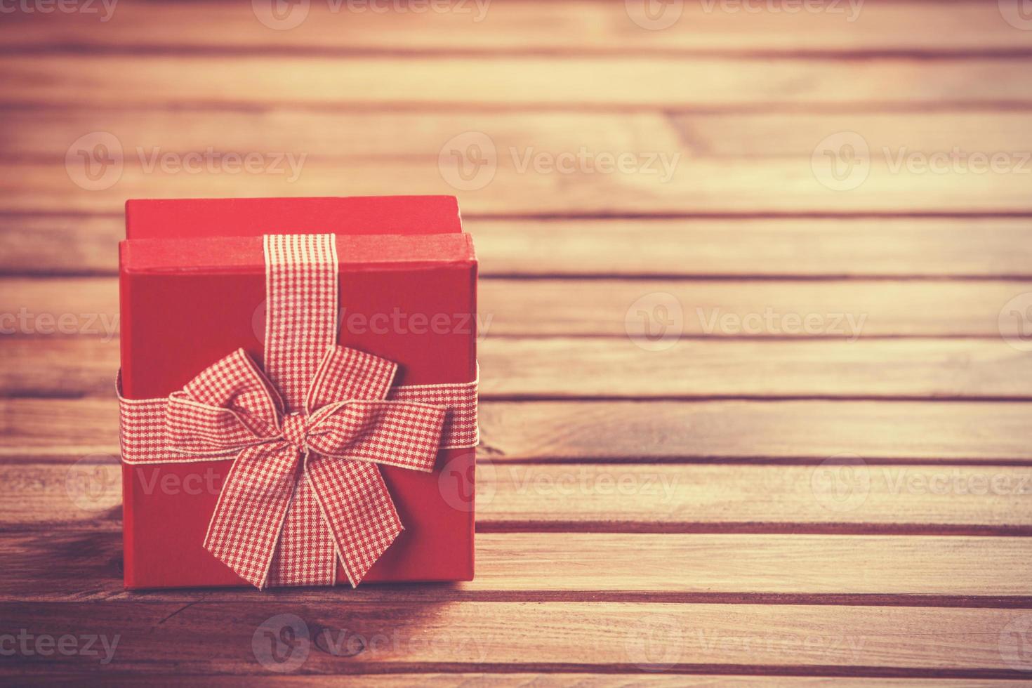 caixa de presente vermelha na mesa de madeira. foto