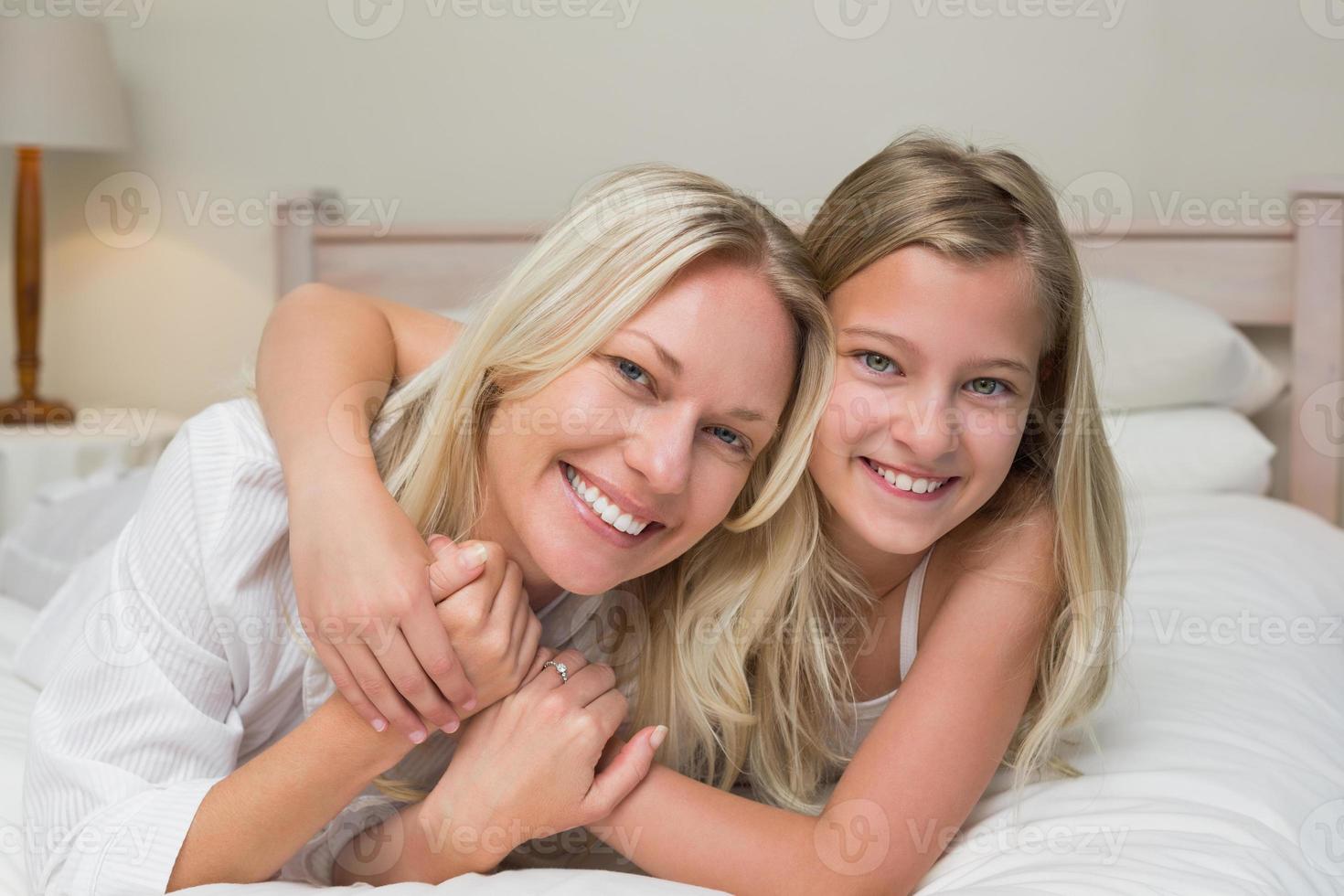 mãe amorosa e filha deitada na cama foto