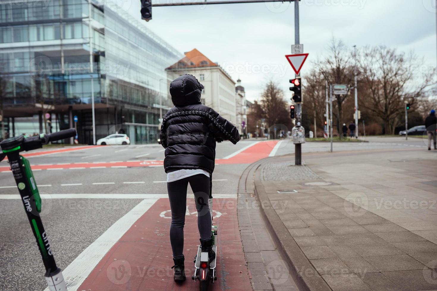 bela jovem montando uma scooter elétrica, estilo de rua foto