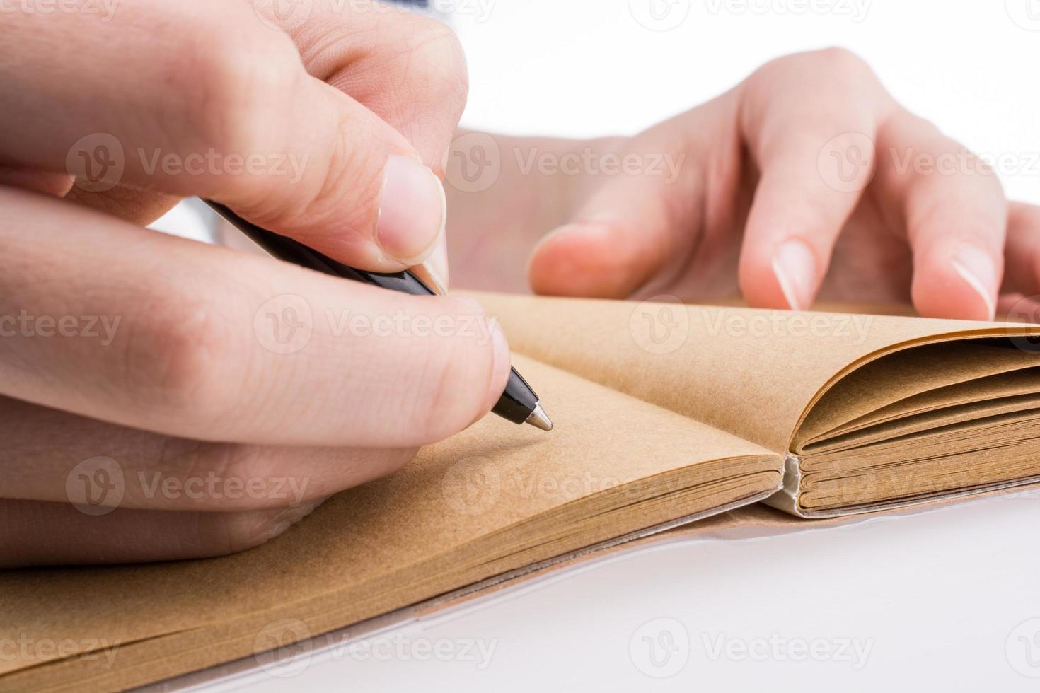 mão escrevendo no caderno foto