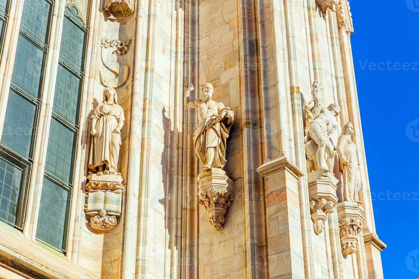 fachada da catedral de milão duomo di milano com pináculos góticos e estátuas de mármore branco. principal atração turística na piazza em milão, lombardia, itália. visão de grande angular da antiga arquitetura gótica e arte. foto