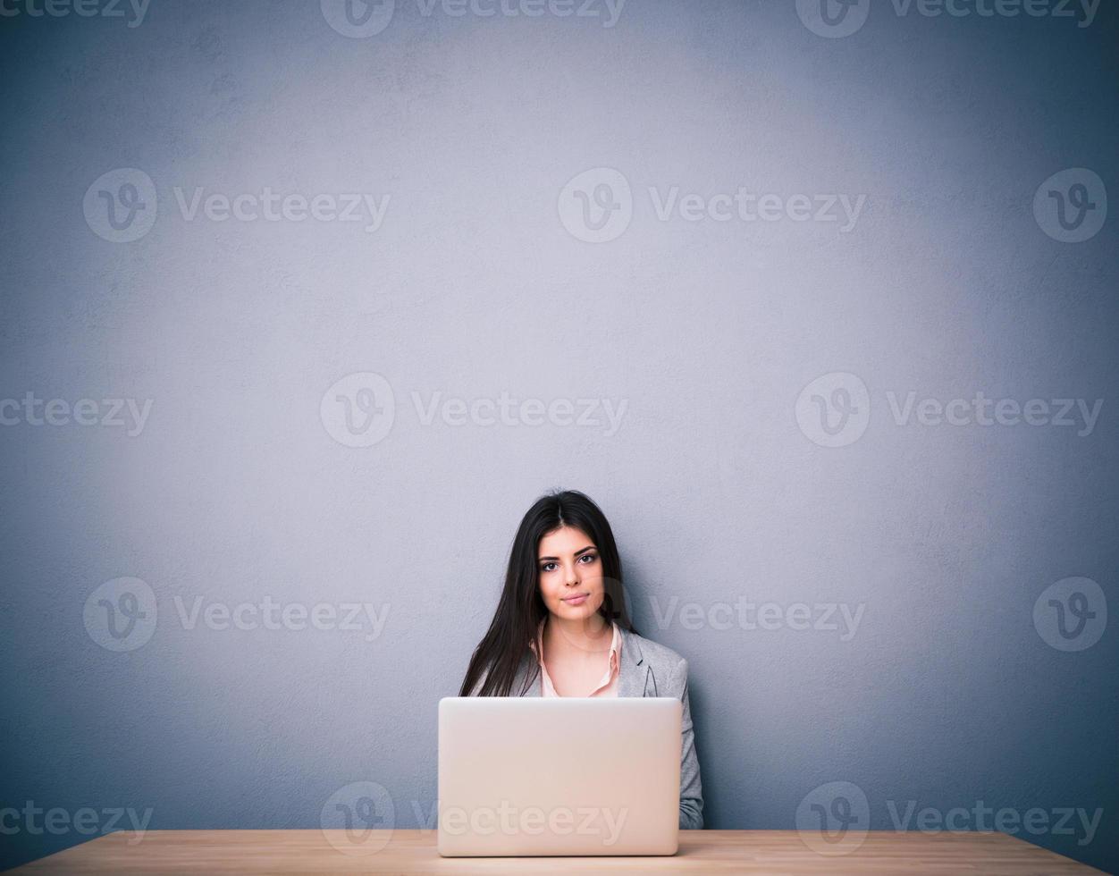 linda mulher sentada na mesa com laptop foto