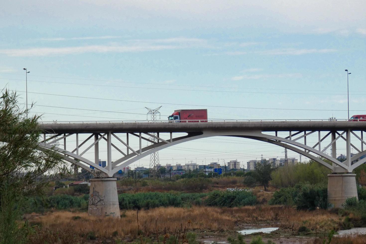 ponte moderna sobre um rio por onde passam grandes veículos e turistas. foto