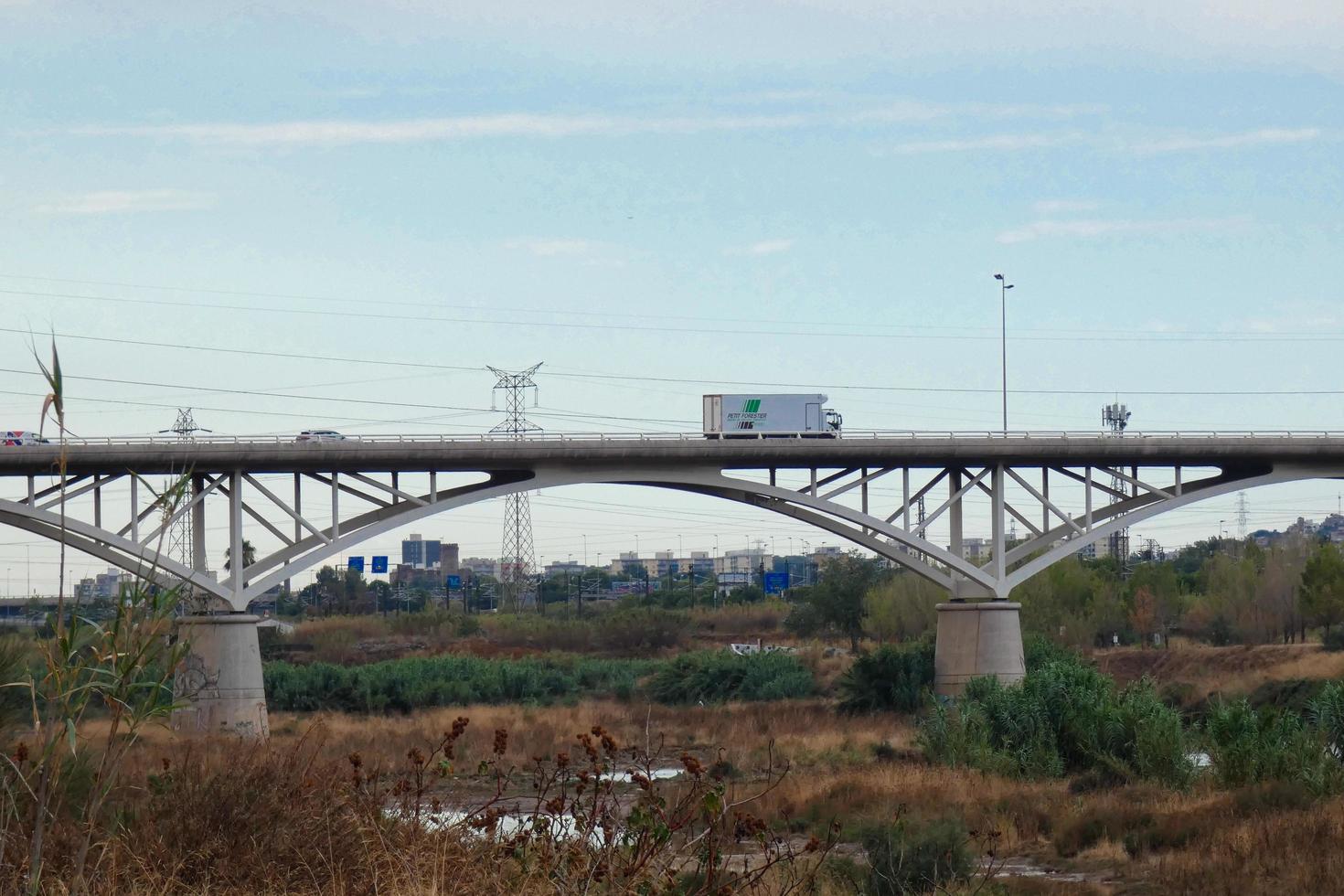 ponte moderna sobre um rio por onde passam grandes veículos e turistas. foto