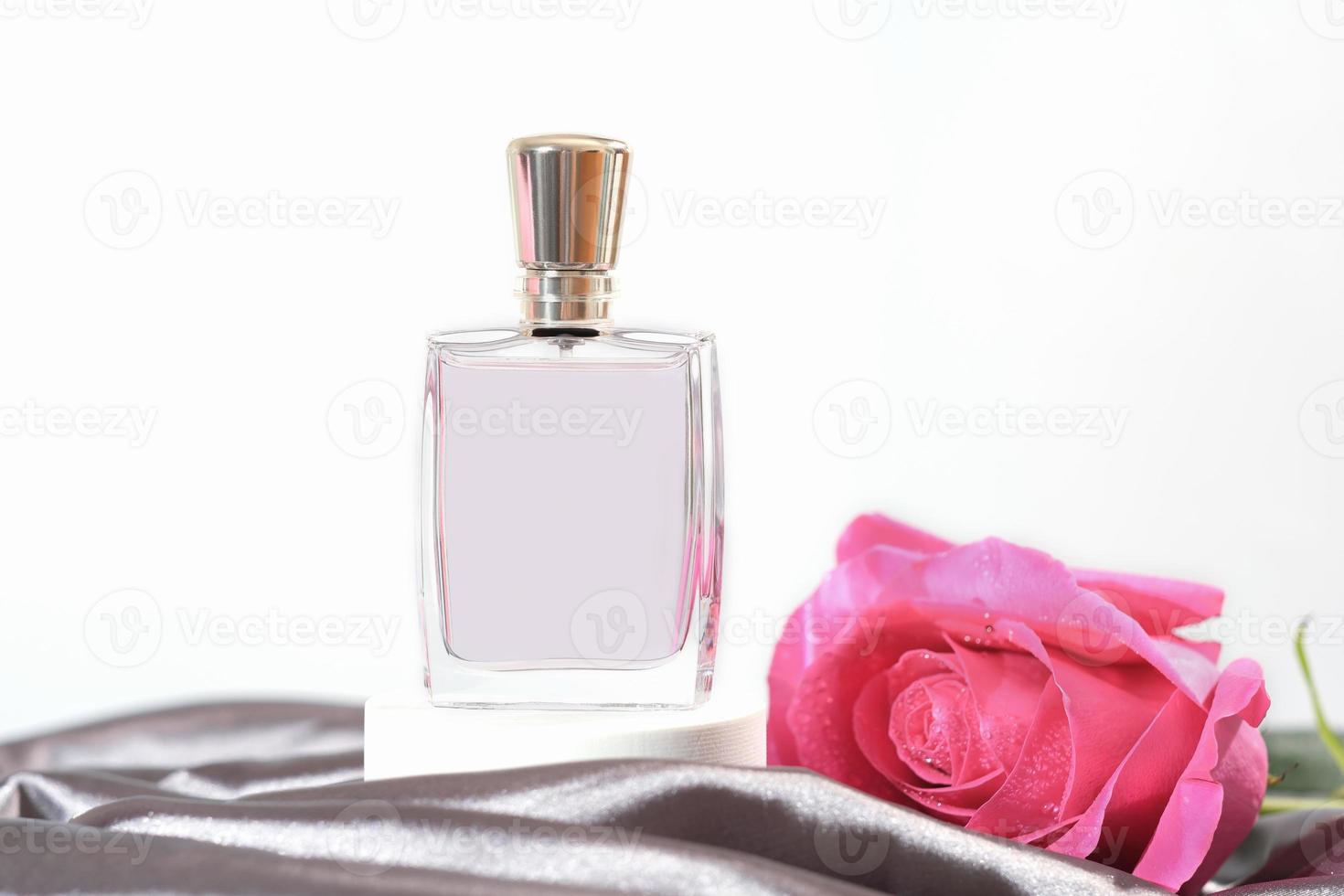 frasco de perfume feminino em um fundo de seda cinza com botão de rosa fresco rosa. presente para uma mulher, fragrâncias para mulheres, loja de perfumaria. foto