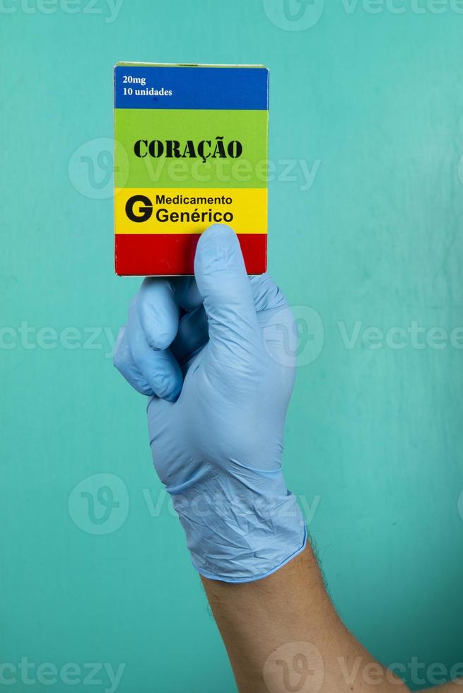 médico segurando a caixa de remédio para o coração escrito na caixa com luvas de proteção foto