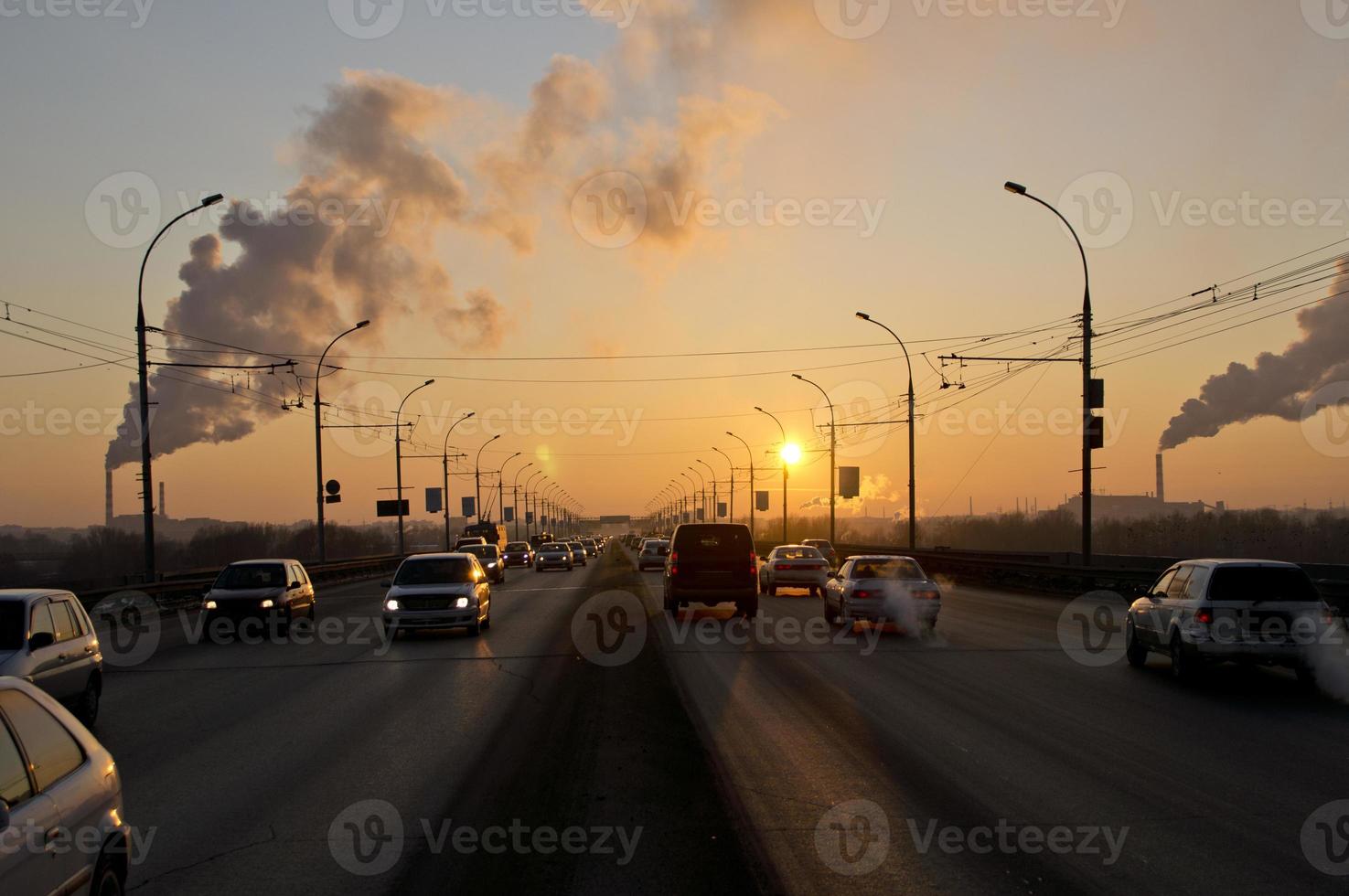 pôr do sol em uma noite gelada de outono sobre a ponte da cidade sobre a qual os carros estão correndo foto