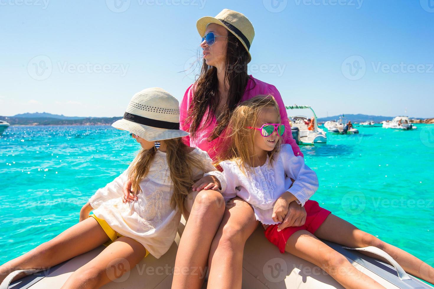 jovem mãe com suas adoráveis meninas descansando em um barco foto