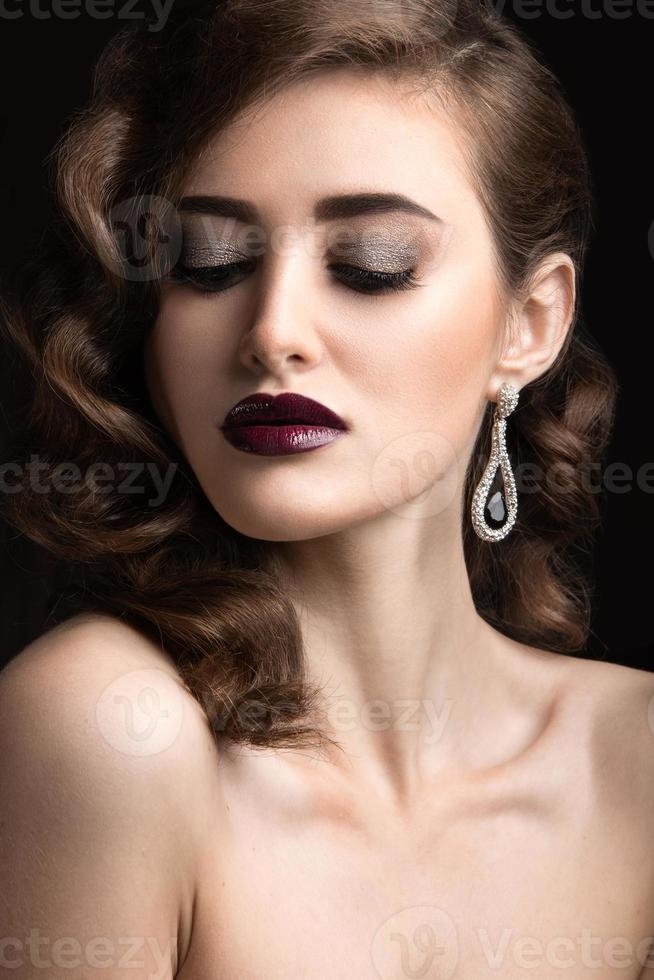 mulher bonita com maquiagem de noite, lábios cor de vinho e cachos. foto