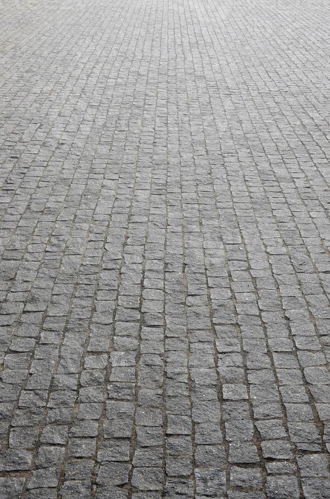 a textura das lajes de pavimentação de muitas pedras pequenas de forma quadrada sob luz solar intensa foto