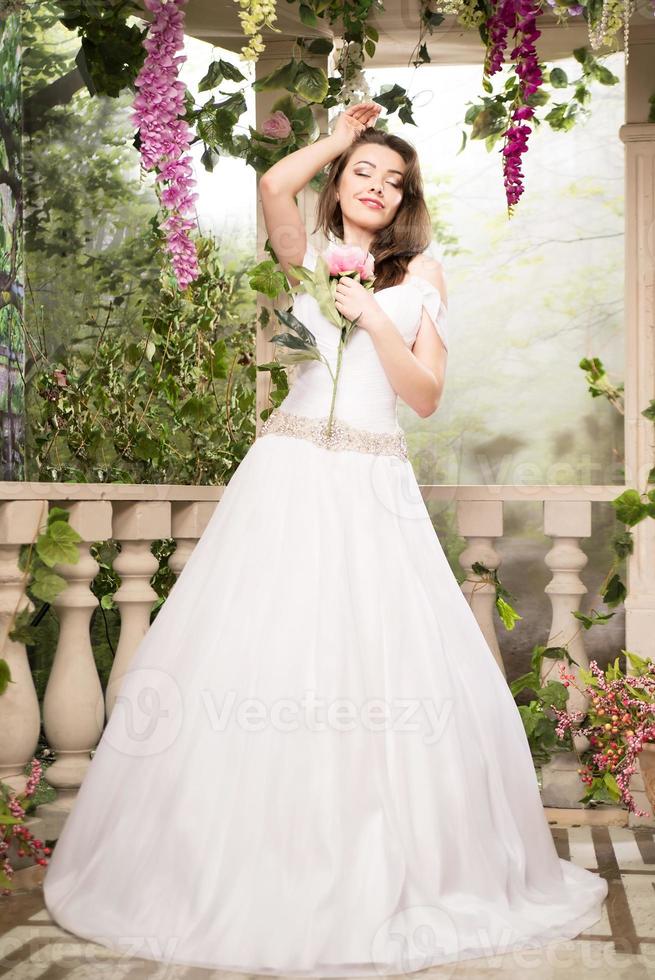 bela mulher de vestido branco. noiva, casamento no jardim. morena foto