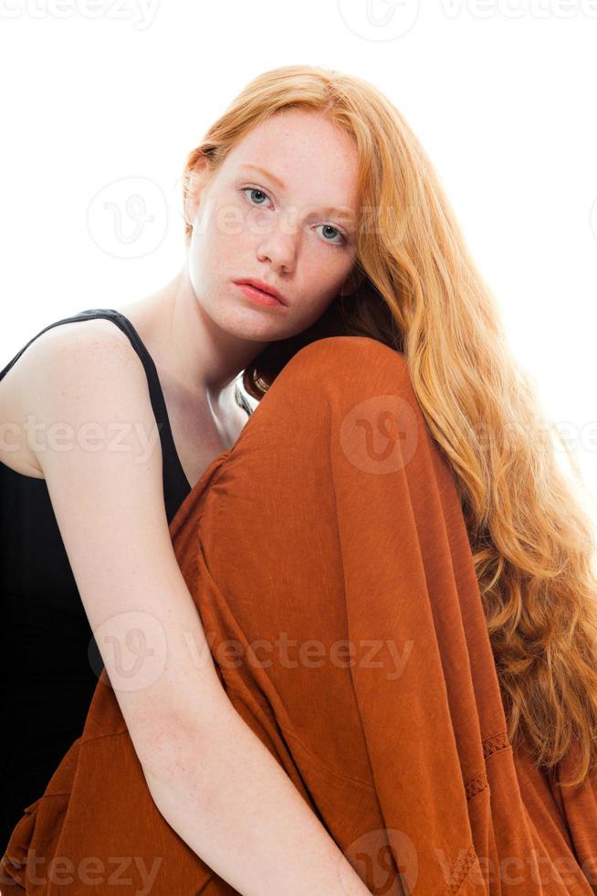 menina bonita com longos cabelos vermelhos usando vestido marrom. foto