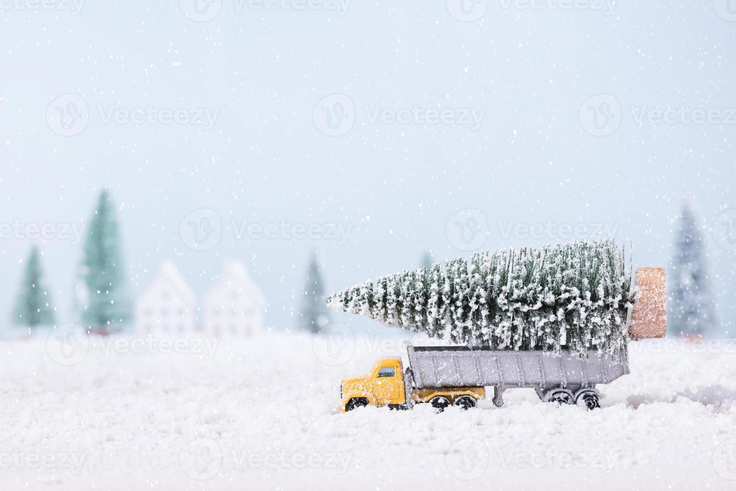 árvore de natal no caminhão de brinquedo estava correndo pela neve no campo de fundo de paisagem natural foto