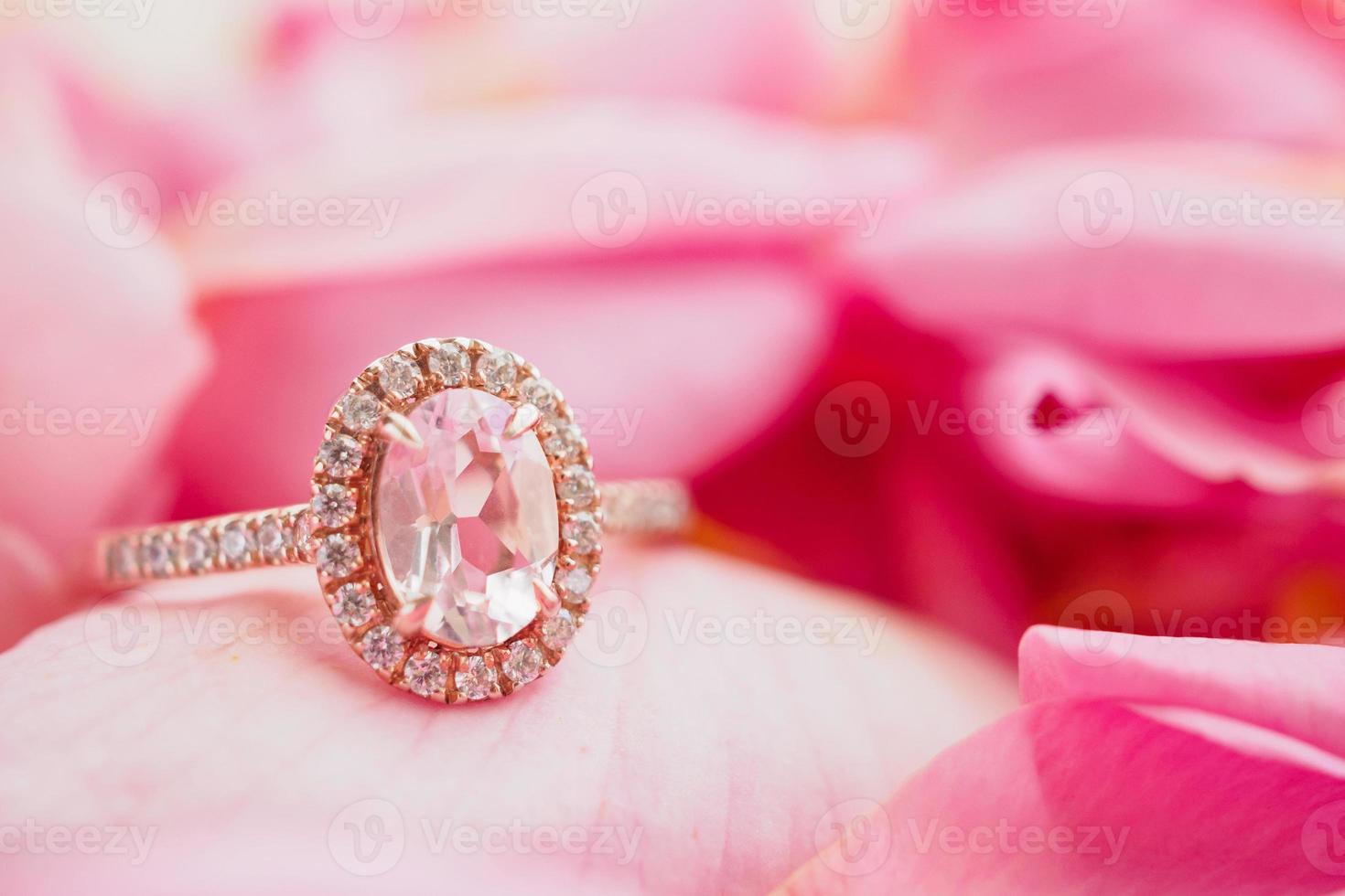 anel de diamante rosa de joias em um lindo fundo de pétalas de rosa close-up foto