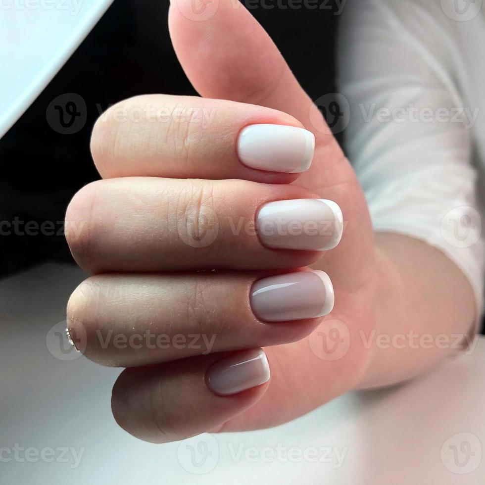 unhas de mulher bonita com bela manicure francesa foto